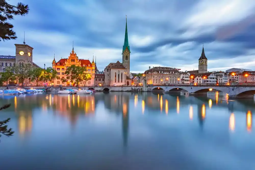 Famous Fraumunster and Church of St Peter with their reflections in river Limmat